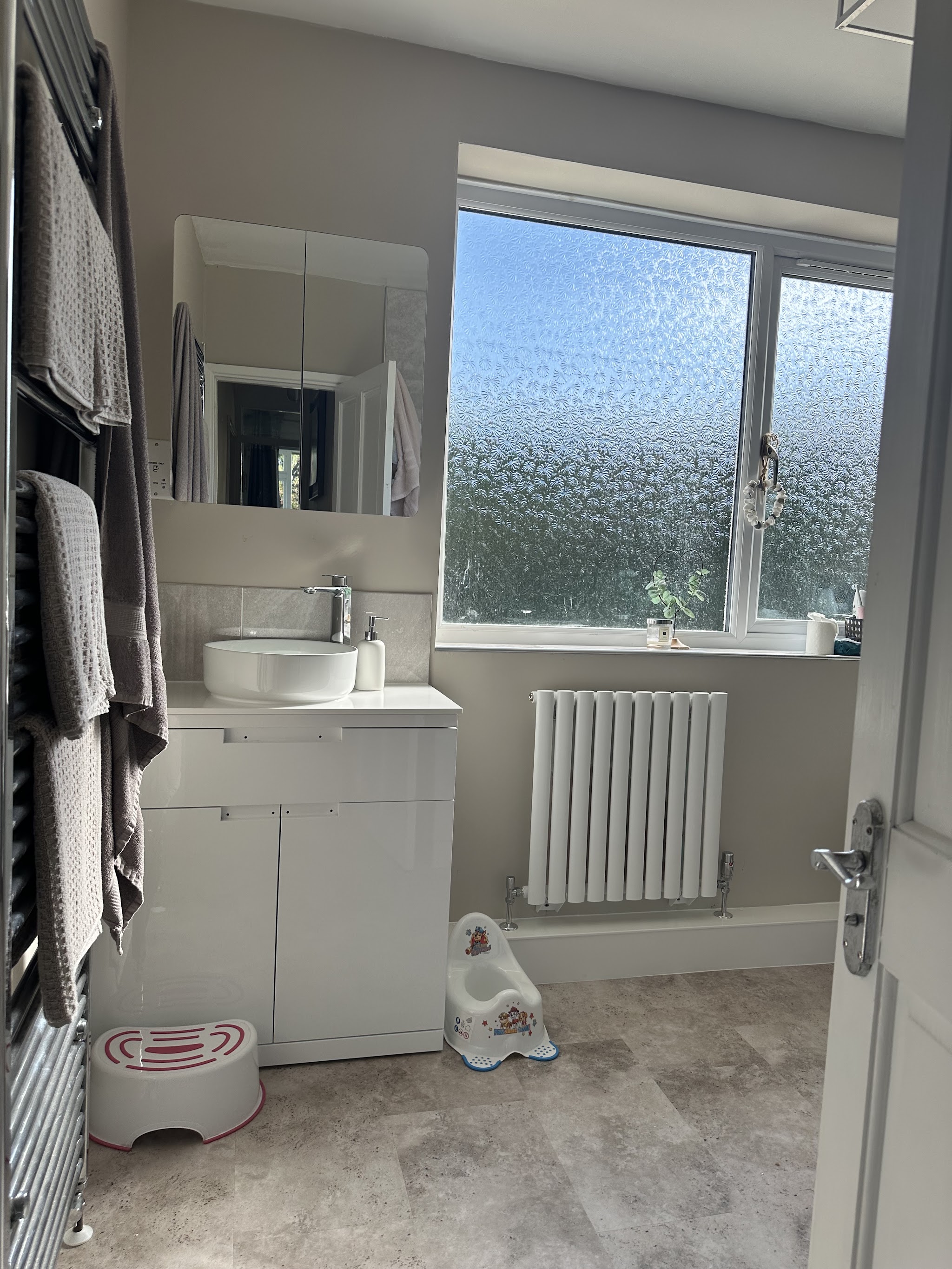 White vanity unit beneath a mirrored cabinet