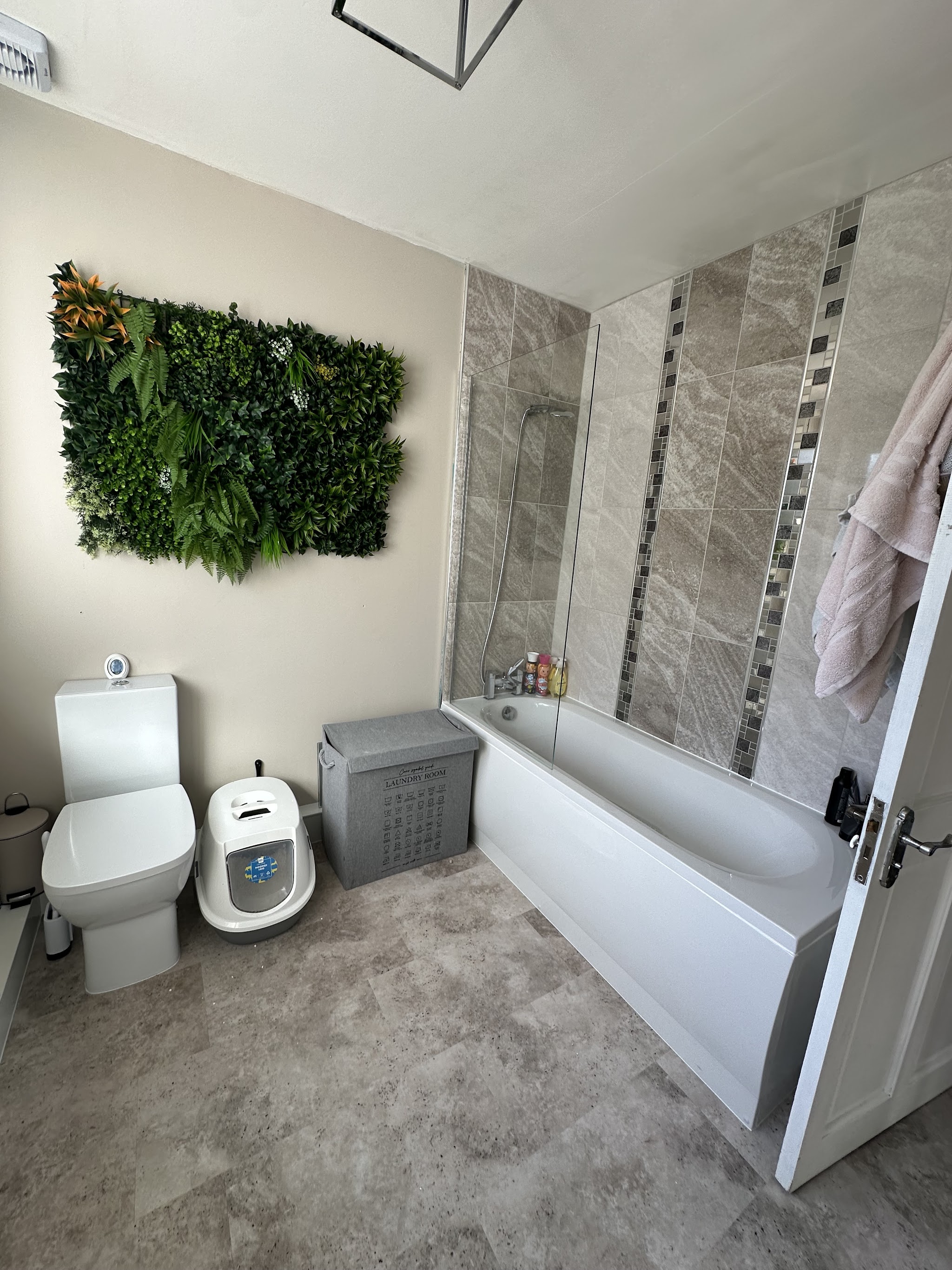Main bathroom with bath, feature tiling and a living wall